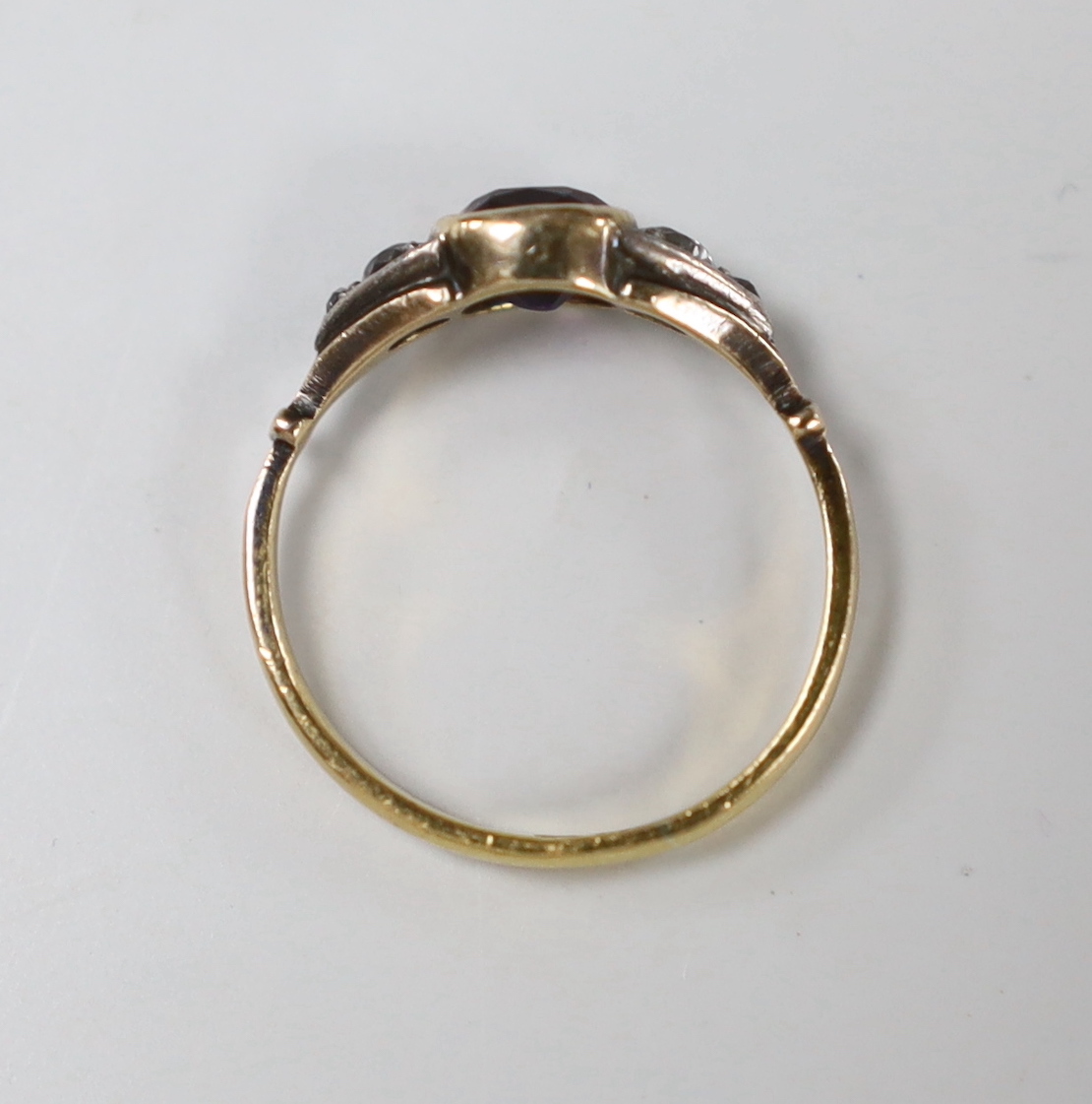 An antique 22ct gold and collet set amethyst ring, with graduated diamond set shoulders, size K, gross weight 2.6 grams.